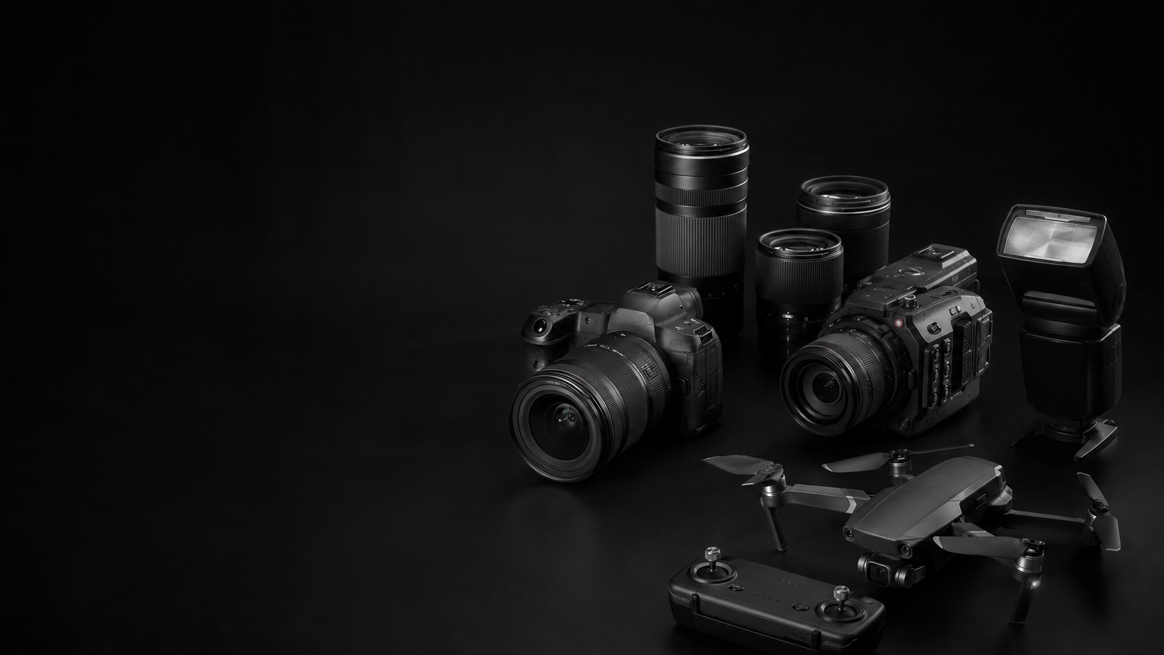 Monochrome collection of professional cameras, lenses, flash and drone used for AJ Studiozz creative productions